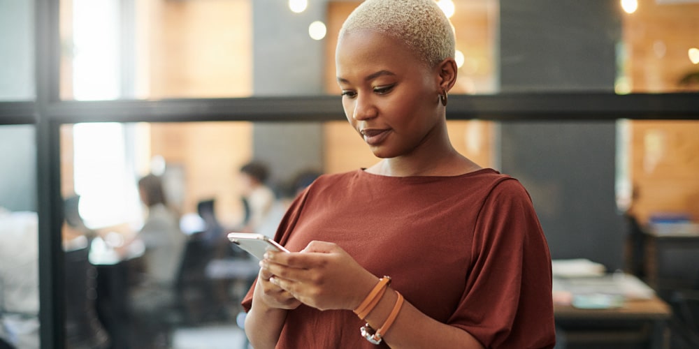 Women viewing smartphone in office type setting.