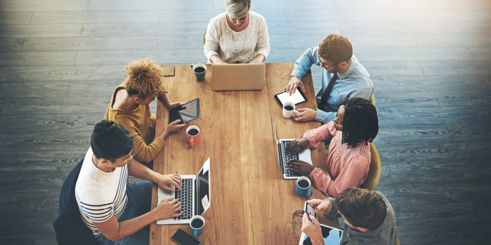 Top down shot of group of workers at a conference table