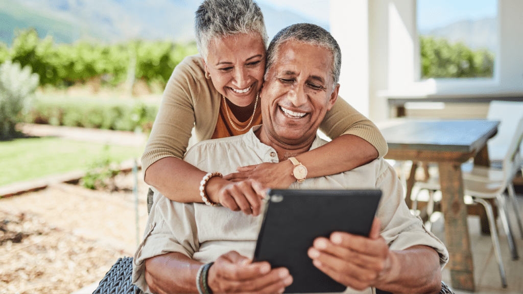 Older couple using a tablet for digital lending services, smiling and engaged.